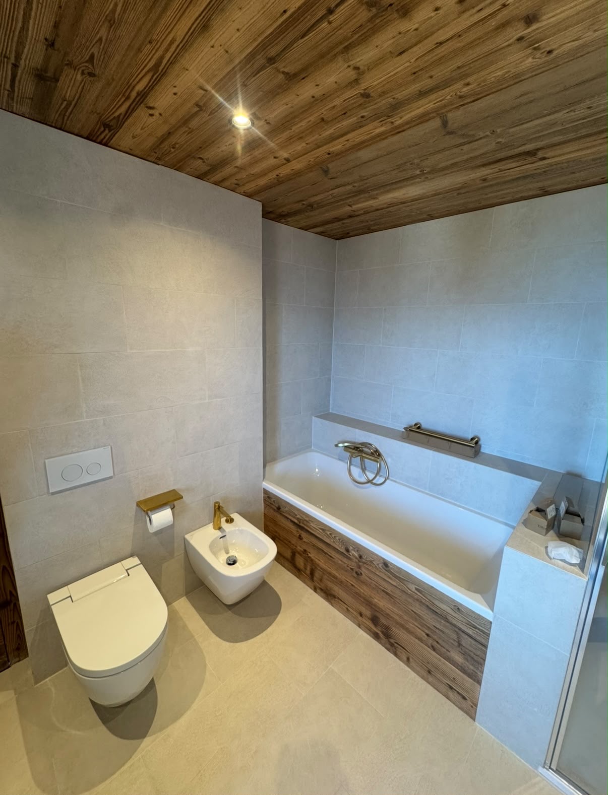 Salle de bain avec baignoire et habillage bois