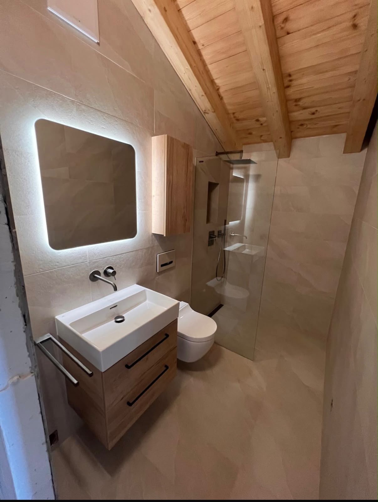 Salle de bain sous combles avec poutres apparentes